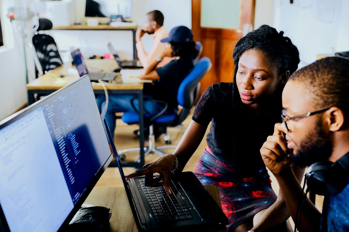 Two engineers working through a problem together at a workstation